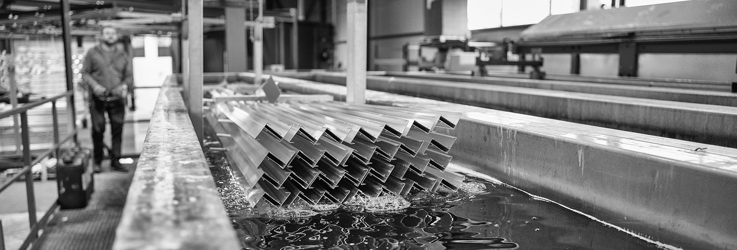 Aluminium profielen in een voorbehandelingsbad in de fabriek